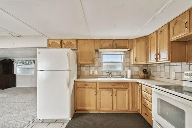 a kitchen with windows and refrigerator