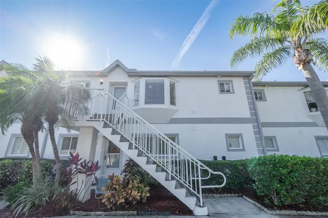 a view of a house with a yard and potted plants