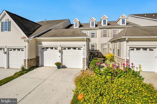 a view of a house with large windows and a flower garden