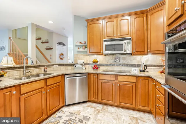 a kitchen with stainless steel appliances granite countertop a sink stove and cabinets