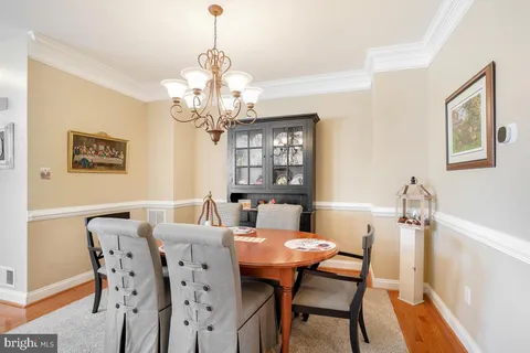 a view of a dining room with furniture a chandelier and wooden floor