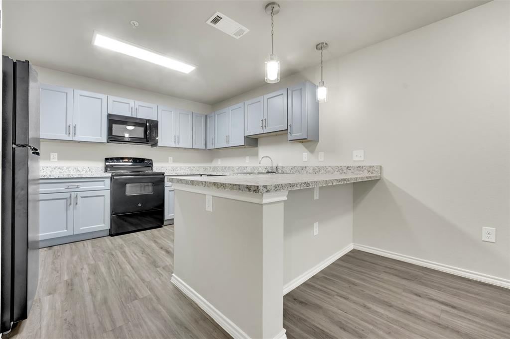 6108 Abrams Road, Unit 201 Dallas, TX 75231 - Photo 6 of 19 a kitchen with a sink a microwave and cabinets