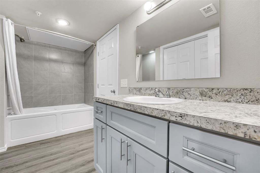 6108 Abrams Road, Unit 201 Dallas, TX 75231 - Photo 8 of 19 a bathroom with a granite countertop sink a toilet and shower
