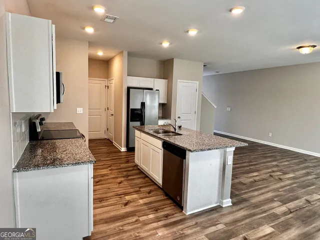 a large kitchen with stainless steel appliances granite countertop a stove and a sink