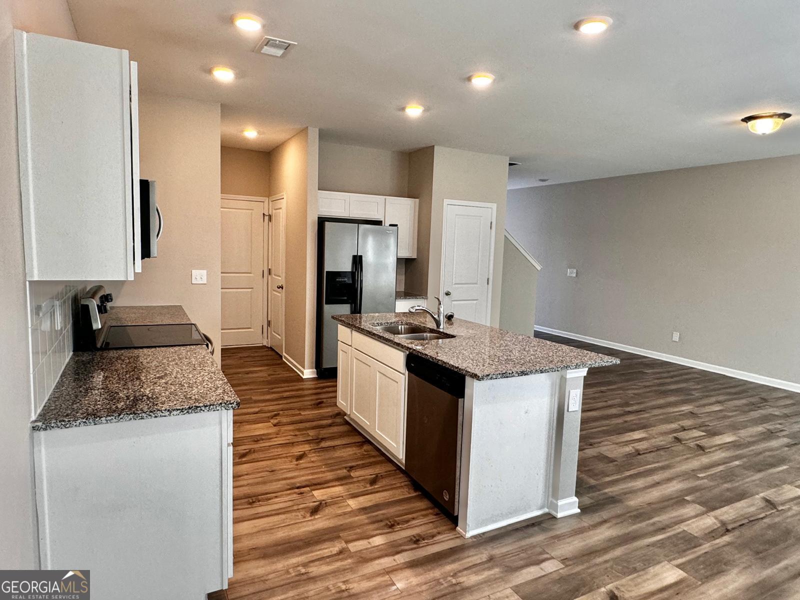1397 Ben Park Way Grayson, GA 30017 - Photo 6 of 17 a large kitchen with stainless steel appliances granite countertop a stove and a sink