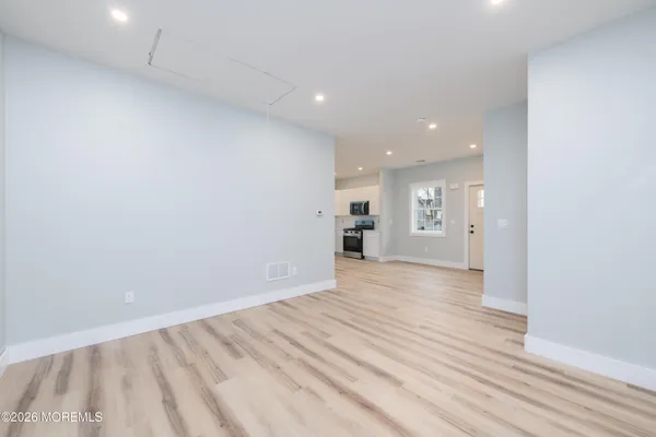 a view of empty room with wooden floor