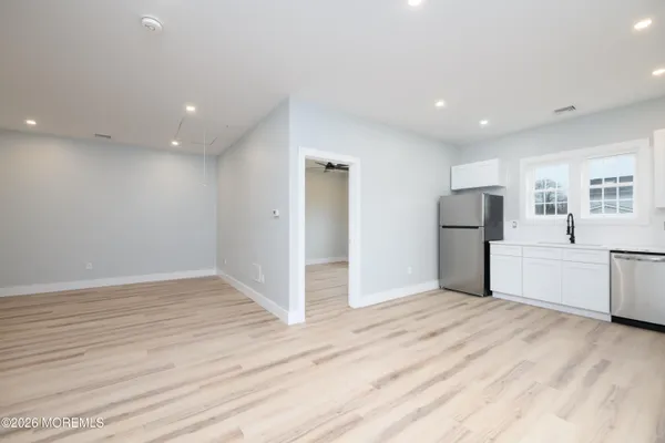 a view of empty room with wooden floor and electronic appliances