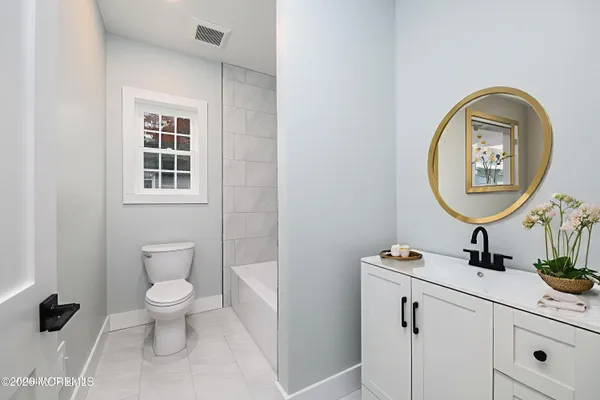 a bathroom with a toilet a sink and a mirror