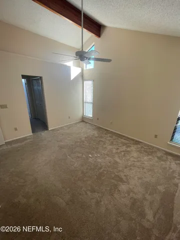 en empty room with ceiling fan and window