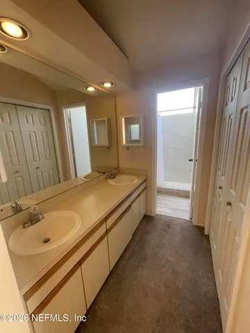 a spacious bathroom with a granite countertop sink and a mirror