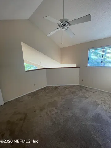 en empty room with windows and fan