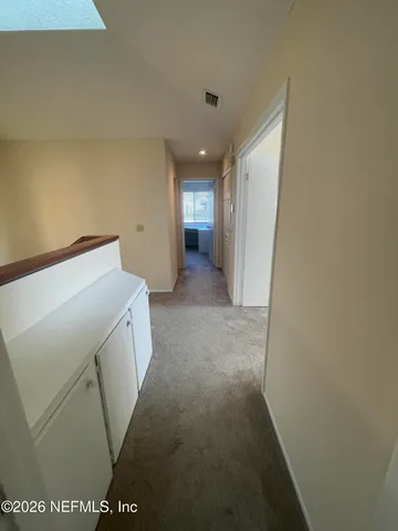 a view of a hallway to rooms