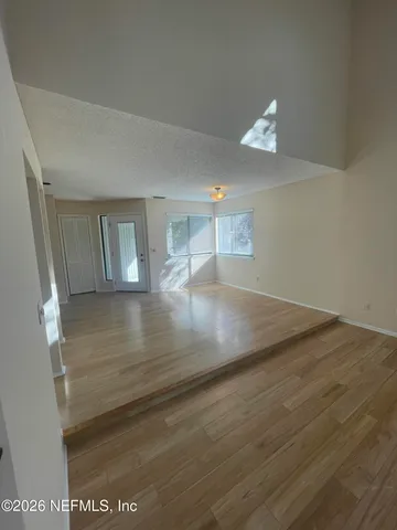 a view of empty room with wooden floor