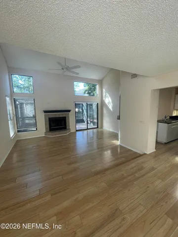 a view of empty room with wooden floor and fireplace