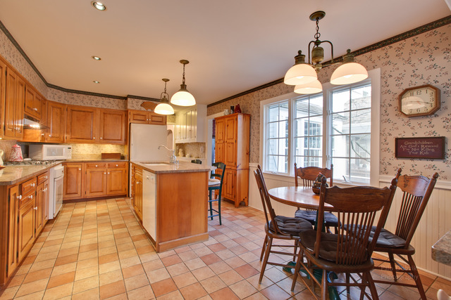 385 Old Sutton Road Barrington Hills, IL 60010 - Photo 10 of 25 a kitchen with stainless steel appliances granite countertop a stove a sink a dining table and chairs