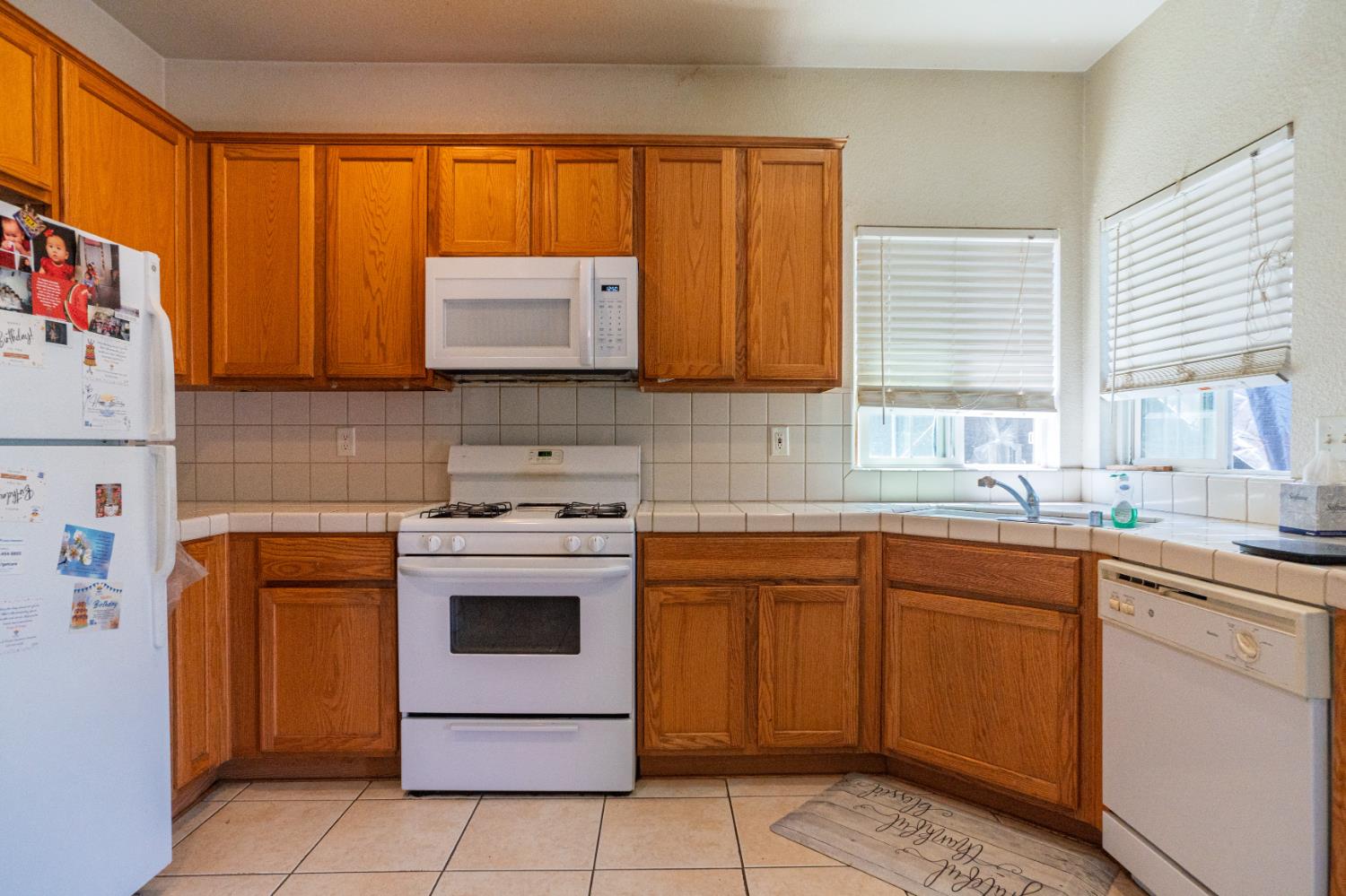 123 Manzanita Avenue Merced, CA 95341 - Photo 7 of 30 a kitchen with a sink stove and cabinets