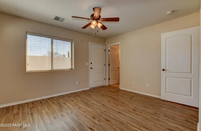 a view of room with window ceiling fan and hardwood floor
