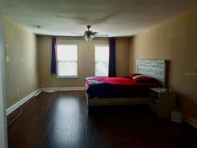 a bedroom with a bed and wooden floor