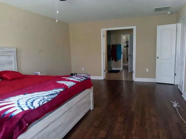 a bedroom with a bed and wooden floor