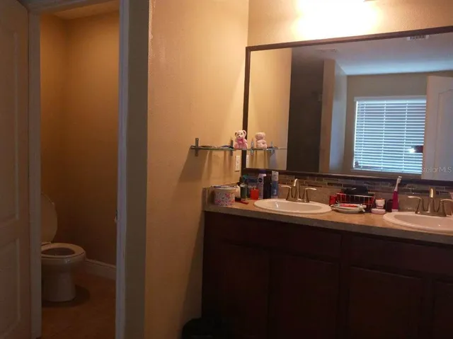 a bathroom with a toilet sink and mirror