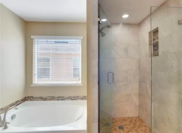 a white bath tub sitting next to a shower