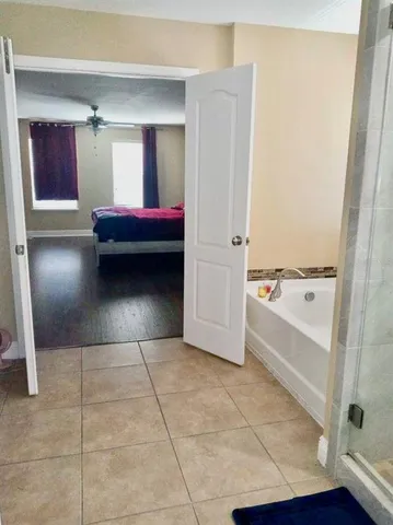 a bathroom with a tub shower and sink