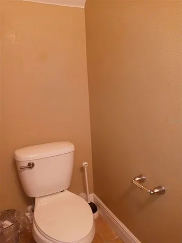 a white toilet sitting next to a white wall
