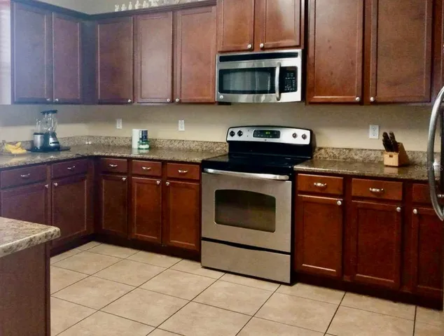 a kitchen with stainless steel appliances granite countertop a stove microwave and cabinets