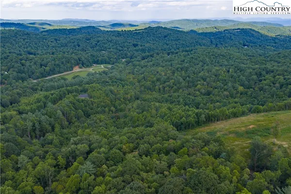 an aerial view of a houses with a lush green hillside