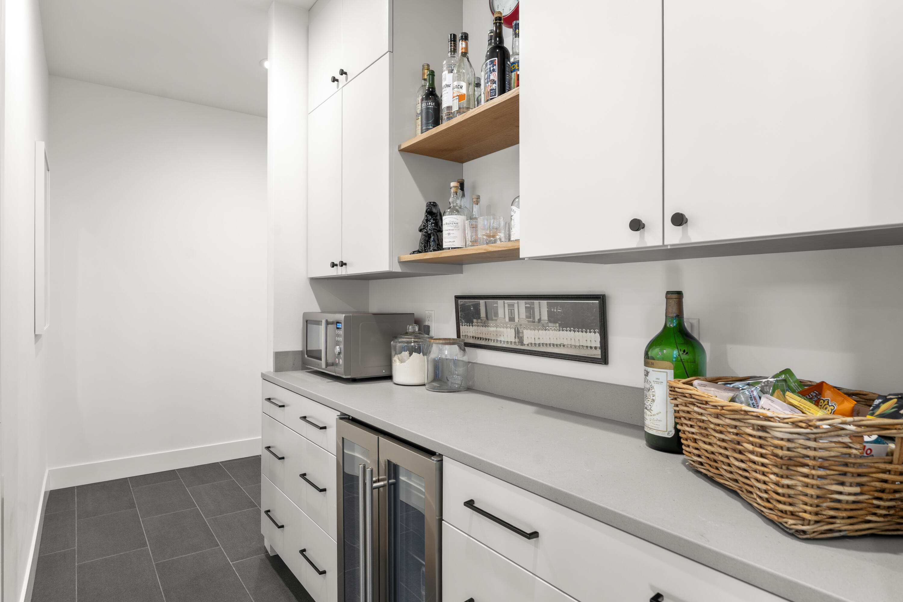 56670 Sunstone Loop, Unit LOT 141 Bend, OR 97707 - Photo 12 of 62 This pantry area combines practical storage with refined finishes, including painted maple cabinetry, soft-close drawers, white oak open shelving, and a built-in wine refrigerator.