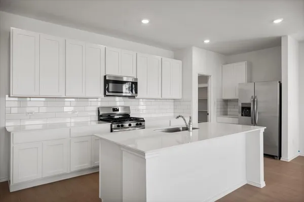 a kitchen with white cabinets and stainless steel appliances