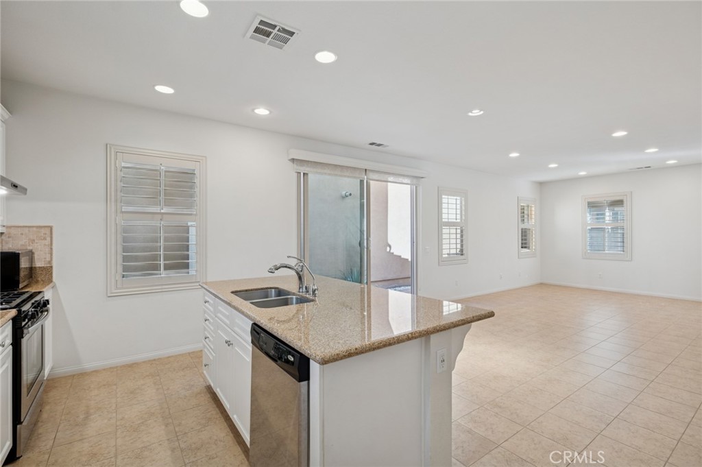 93 Keepsake Irvine, CA 92618 - Photo 11 of 25 a kitchen with kitchen island a sink stainless steel appliances and window