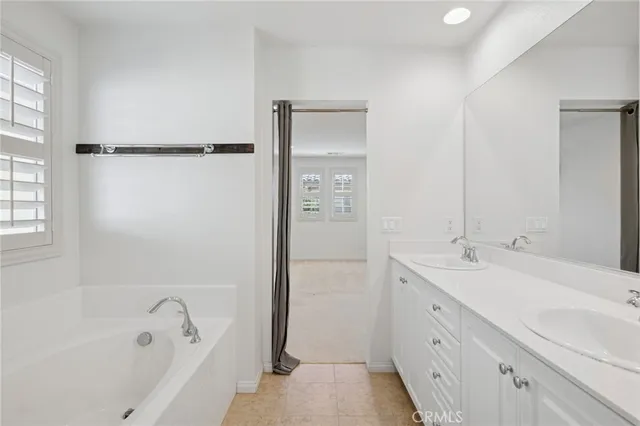 a bathroom with a tub sink and mirror