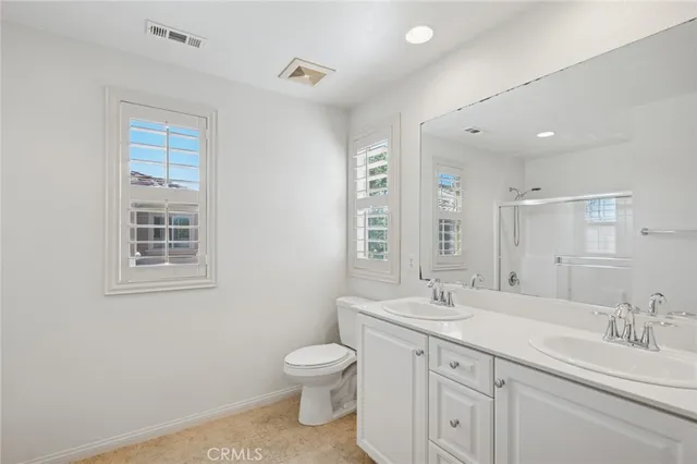 a bathroom with 2 sink toilet and a mirror