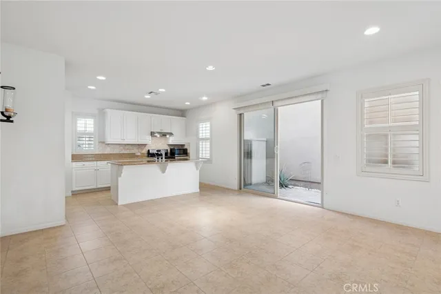 a view of a kitchen with kitchen island a counter top space a sink stainless steel appliances and cabinets