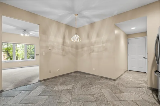a view of a livingroom with a chandelier fan and windows