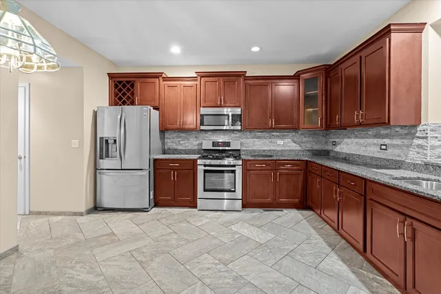 a kitchen with stainless steel appliances granite countertop a refrigerator sink and cabinets