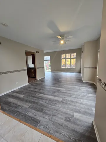 a view of empty room with wooden floor and window