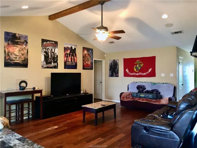 a living room with furniture a flat screen tv and a piano