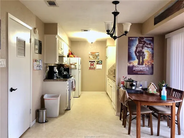 a view of a dining room with furniture and a chandelier fan