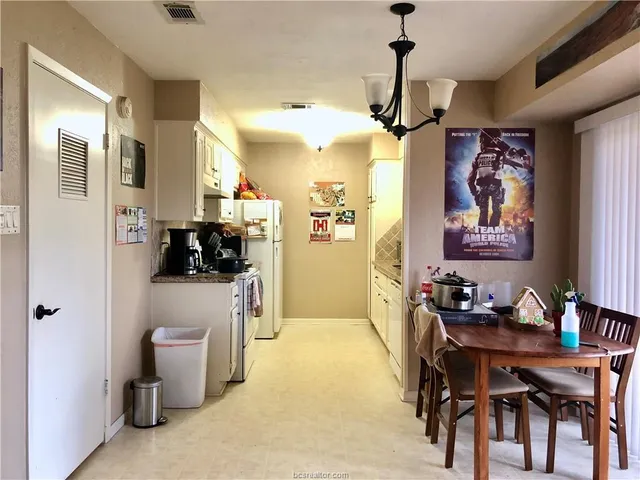 a view of a dining room with furniture and a chandelier fan