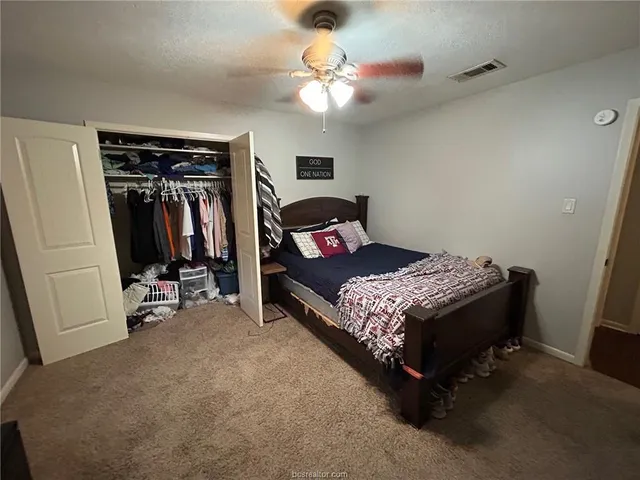a bedroom with bed and a chandelier