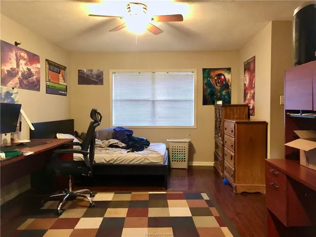 a bedroom with a bed and wooden floor