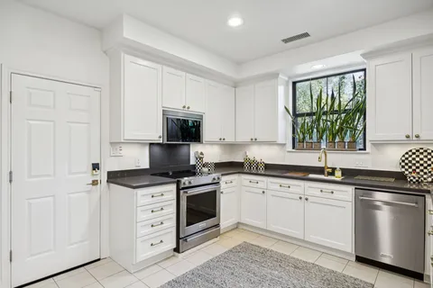 a kitchen with cabinets appliances a sink and a window
