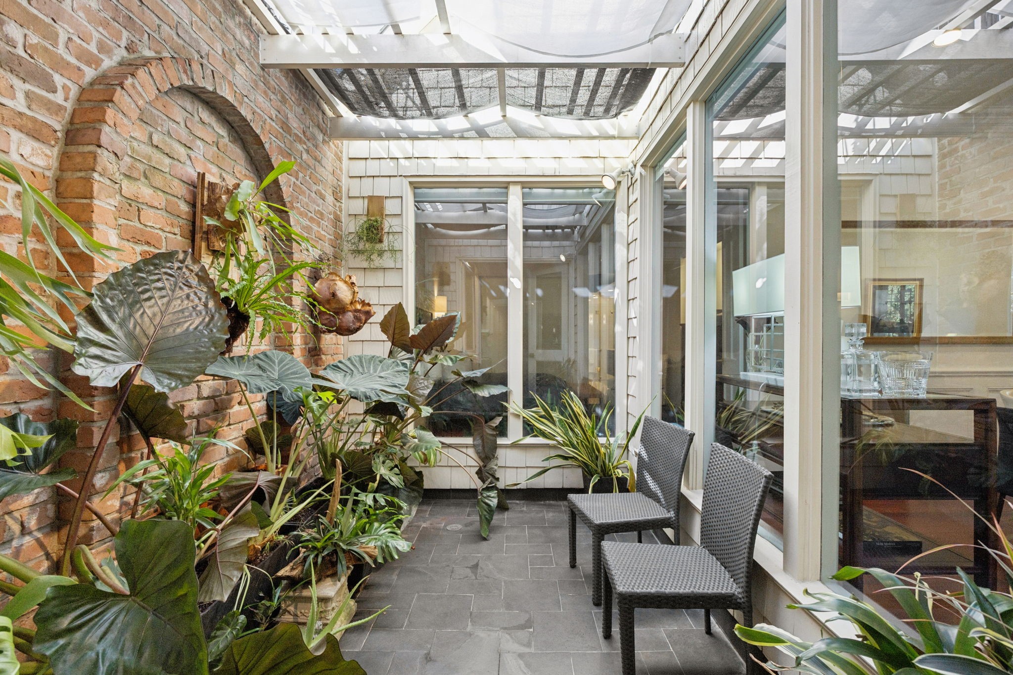 4964 Post Oak Timber Drive Houston, TX 77056 - Photo 29 of 48 Southern lit atrium with aluminum lattice cover and woven sails highlights the beautiful brick accent wall.