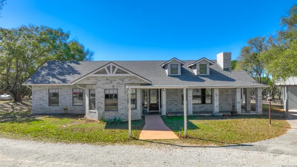a view of a house with a backyard and a tree