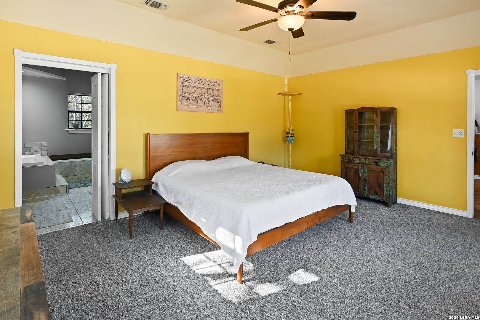 713 Lake Forest Road Pipe Creek, TX 78063 - Photo 15 of 65 a bedroom with a bed and a chandelier