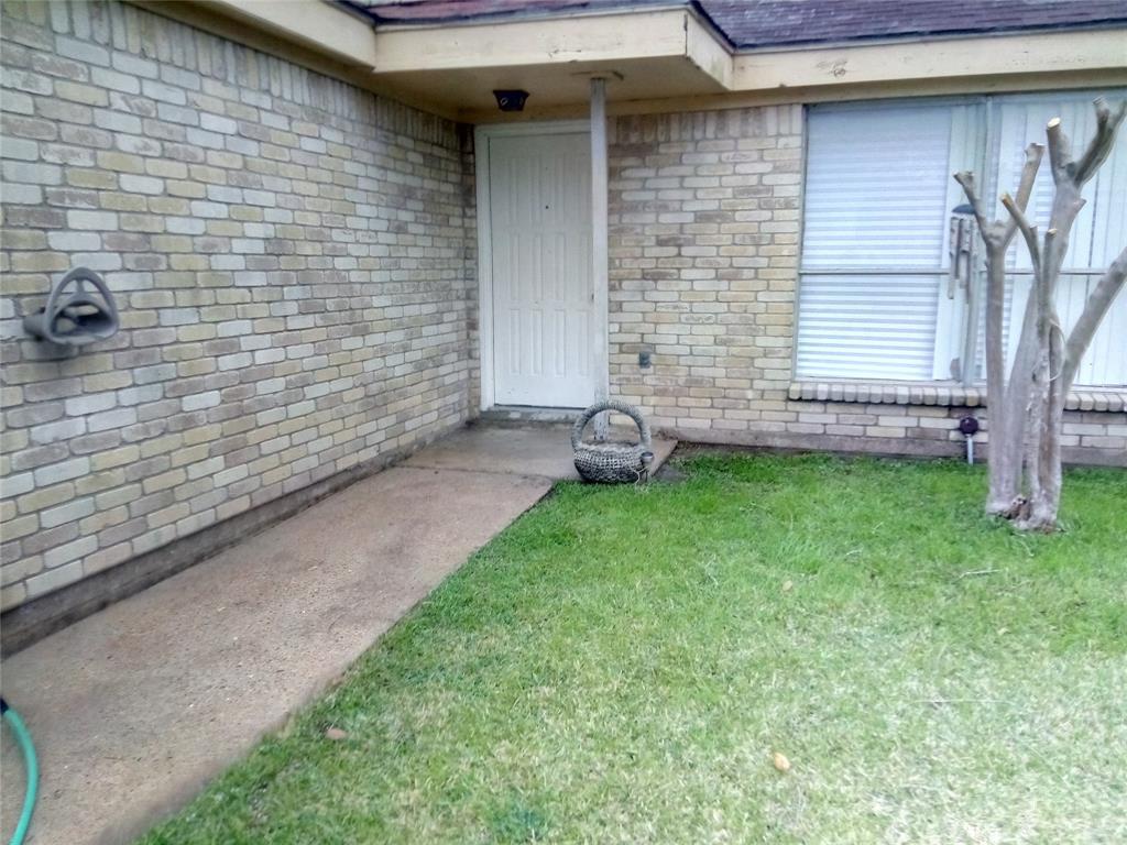 a view of a backyard with table and chairs and a brick wall