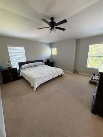 a spacious bedroom with a bed and a chandelier