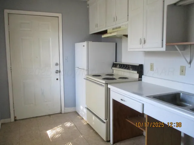 a kitchen with white cabinets and white appliances
